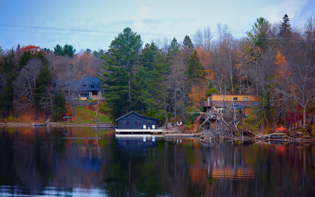 Captivating autumn scenery by a lake in Huntsville, Ontario showcasing tranquil reflection and vibrant foliage.
